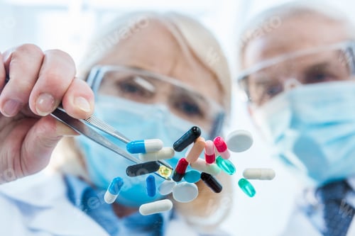 Preview: Close-up view of scientists in protective workwear working with various pills