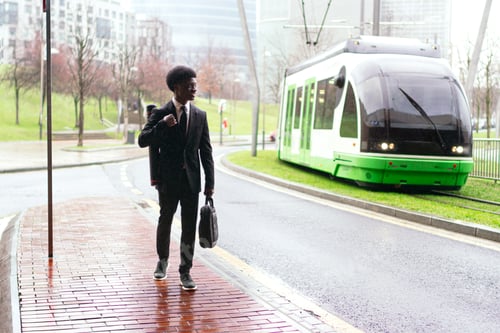 Preview: Young African Entrepreneur Waiting for Tram on Rainy Day