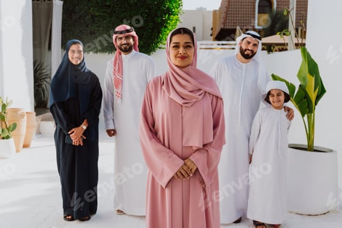 Preview: Emirati family standing together smiling in traditional attire