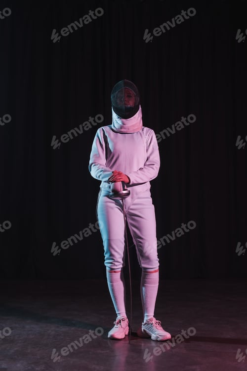 Preview: Fencer in fencing suit and mask holding rapier on black background