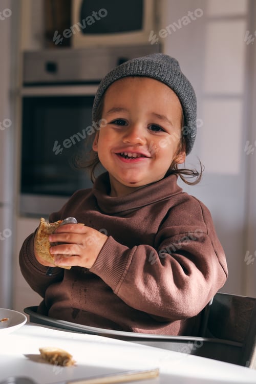 Preview: Cute little boy eating pancake in kitchen