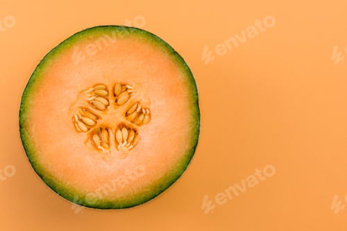 Preview: Cantaloupe Orange Melon Sliced in Half on Pastel Background