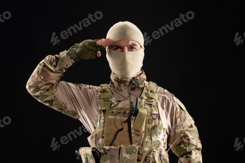 Preview: front view of young soldier in uniform and mask on black background warrior israel