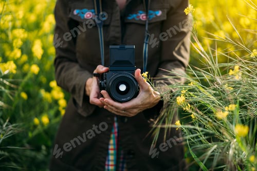 Preview: Woman staying in field with camera