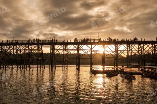 Preview: Ancient wooden bridge with tourists travel at sunset