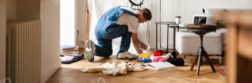Preview: Young white man wearing overall working on craft rug at home