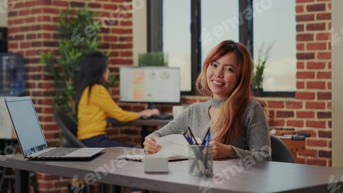 Preview: Portrait of asian woman analyzing documents with graphs