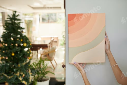 Preview: Woman Hanging Pictures on Wall