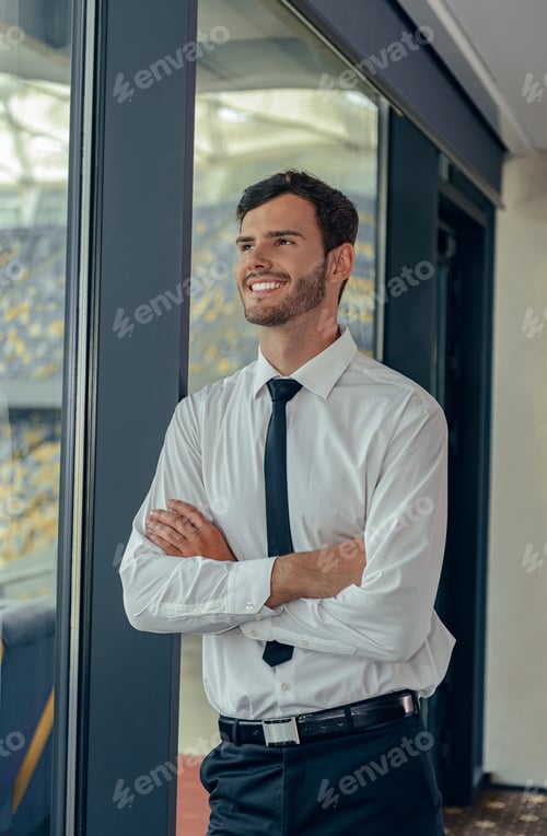 Preview: Vertical photo of businessman in white shirt standing by the window