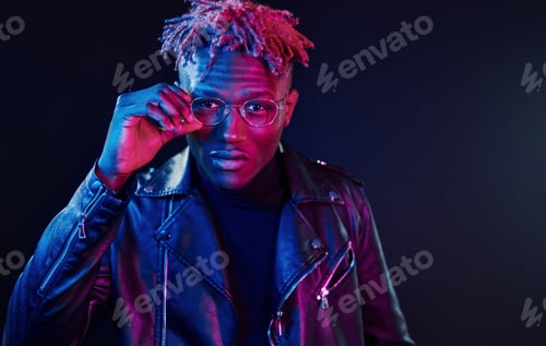 Preview: Having fun. Futuristic neon lighting. Young african american man in the studio
