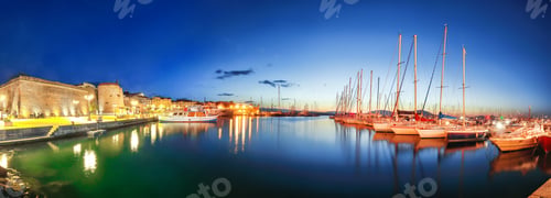 Preview: Night view of the Alghero Marina yacht port at the Gulf of Alghero with anchored sailboats