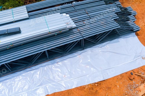 Preview: Steel rods beams stacked neatly on construction site under clear sky in daylight hours