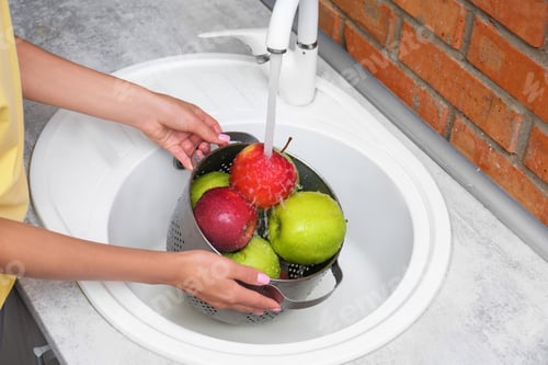 Preview: Woman washing fresh apples in kitchen sink, closeup