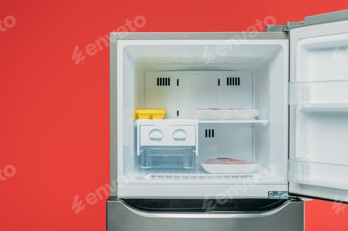 Preview: frozen meat and ice in open freezer isolated on red