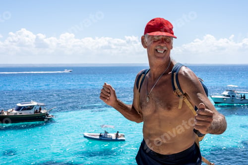 Preview: Active senior man standing on cliff by the sea in Favignana, Sicily