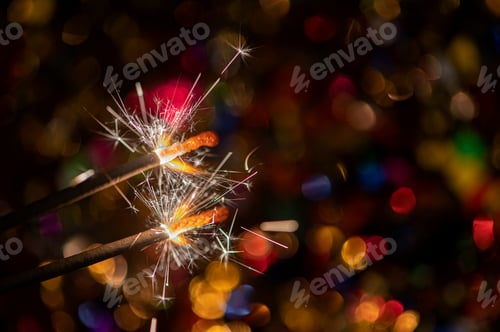 Preview: Happy New Year, Glittering burning sparkler against blurred confetti bokeh light background