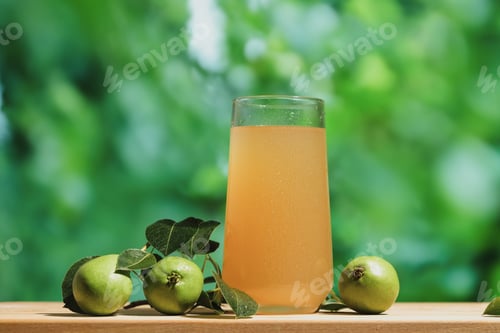 Preview: Glass of pear juice outdoors.