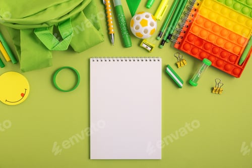 Preview: Mockup from notebook with school stationery supplies on green background. Top view. Copy space