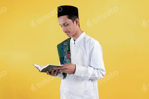 Preview: Muslim Man Wear White Shirts with Traditional Islamic Ornaments and Prayer Mat while Reciting Quran