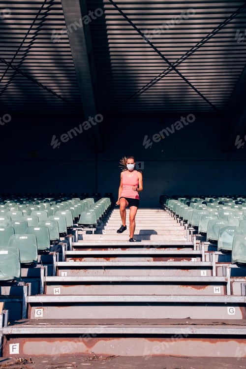 Vorschau: Sportfrau mit Schutzmaske beim Sport im Stadion