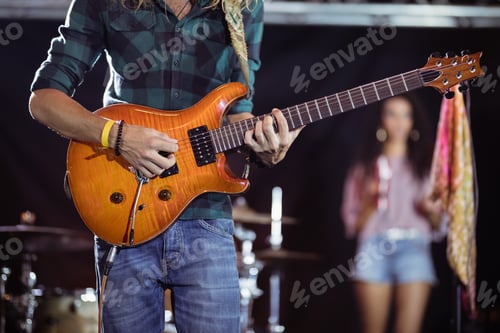 Preview: Guitar Player Performing on Stage at Night
