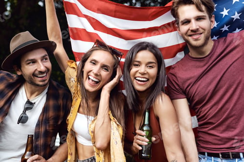 Preview: Portrait of group of young friends celebrating 4th of July on the camping
