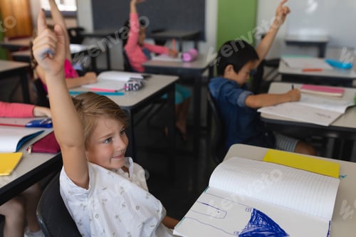 Preview: Side view of school kids raising hand in classroom