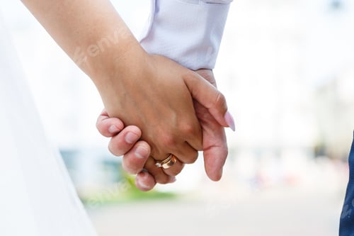 Preview: gold wedding rings in the hands of the newlyweds