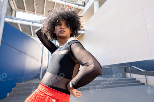 Preview: Young non binary afro-haired person posing moving outdoors