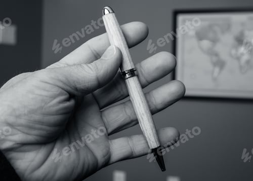Preview: Grayscale of a hand of a person holding a pen