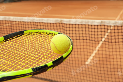 Preview: Tennis racquet with tennis ball against clay court
