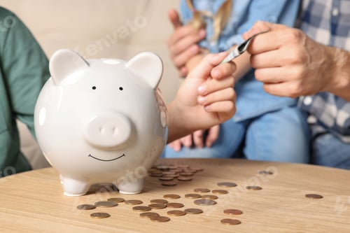 Preview: Family with money and piggy bank at home, closeup