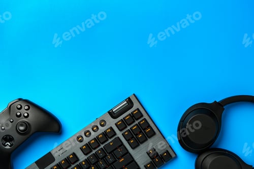 Preview: Computer keyboard and joystick on blue background top view