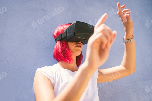 Preview: Young redhead woman playing with virtual reality visor