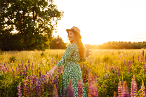 Preview: A beautiful woman with a bouquet of lupins, collects flowers, inhales fresh floral air.