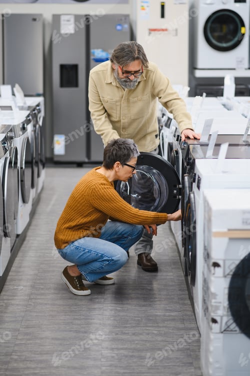 Preview: Senior couple choosing new washing machine in appliance store