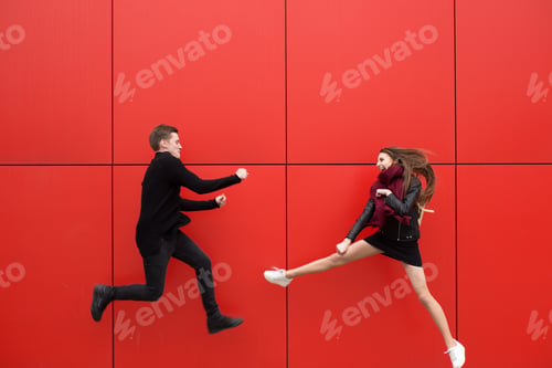 Preview: Fight in jump. A man and a woman on a red background