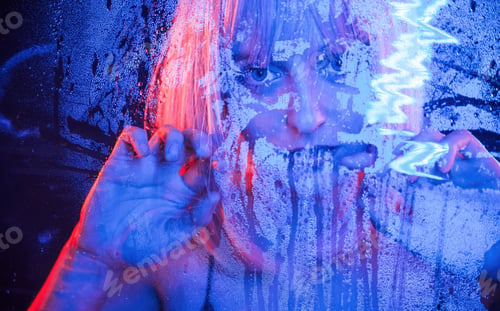 Preview: Cold blue color. With hands on the wet transparent plastic sheet. Stylish woman with white hair
