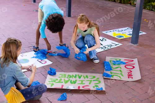 Preview: Happy diverse schoolchildren making ecology posters during outdoor school art class