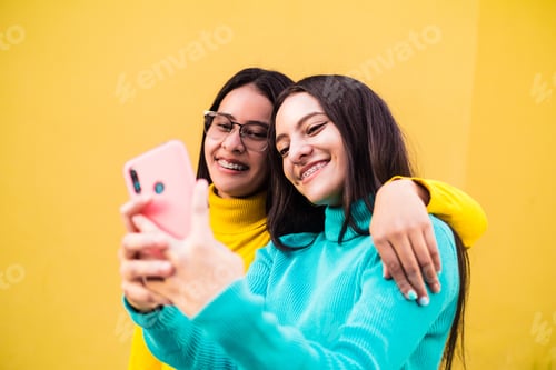 Preview: Closeup shot of cheerful smiling young ladies taking a selfie
