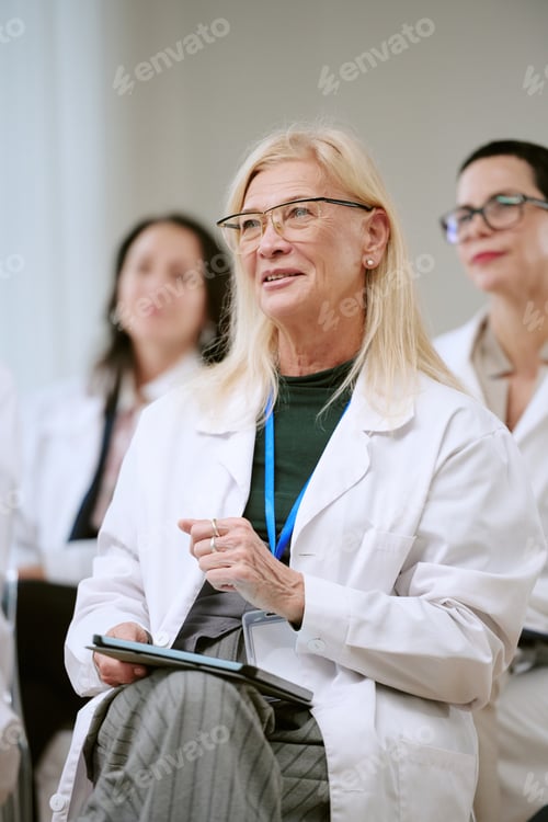 Preview: Senior Woman Doctor Attending Medical Seminar with Colleagues