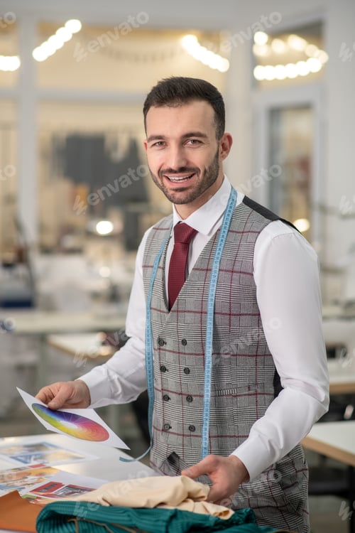 Preview: Male tailor holding color palette, choosing cloth, smiling