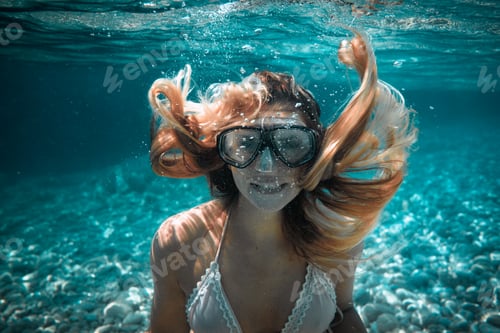 Preview: Beautiful woman with long hair underwater portrait in the tropical sea