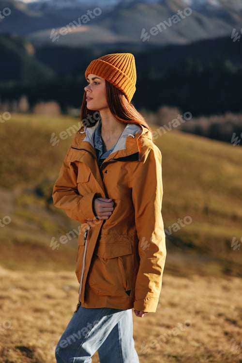 Preview: Woman fall stands a smile travels to the mountains in nature on a hike and happiness in a yellow
