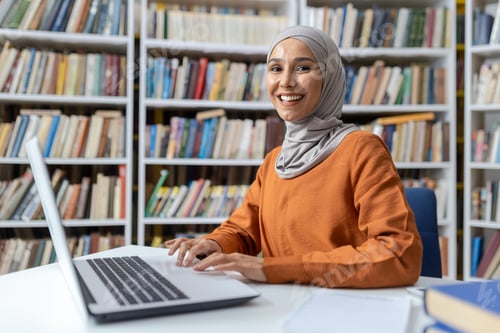 Preview: Smiling young woman using laptop in library setting