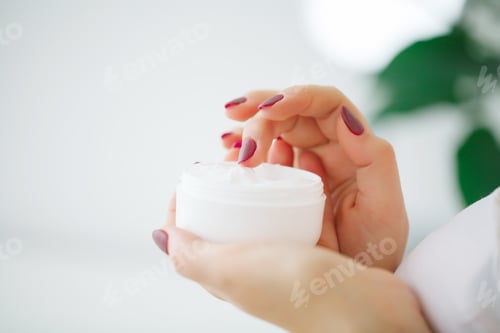 Preview: Woman Applying White Cream to Finger at Home