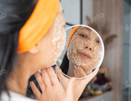 Preview: Portrait of a happy Asian woman using natural secrets for skin care (ingredients on the table: oats,
