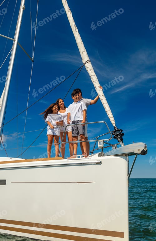 Preview: Smiling Latin American family standing on private yacht
