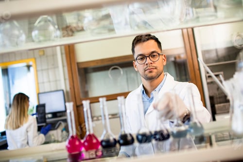 Preview: Young researcher checking test tubes