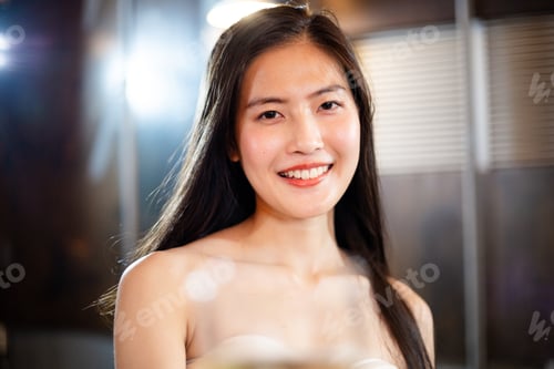 Preview: Portrait of attractive Asian woman toasing glass of wine to camera